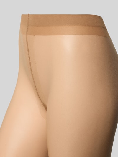 Frauenmodel trägt Transparente Strumpfhose Modell 'SHELINA 12 DEN' von Falke, Körpernahe Passform, Elastischer Bund, Transparent, Nahaufnahme Oberkörper.