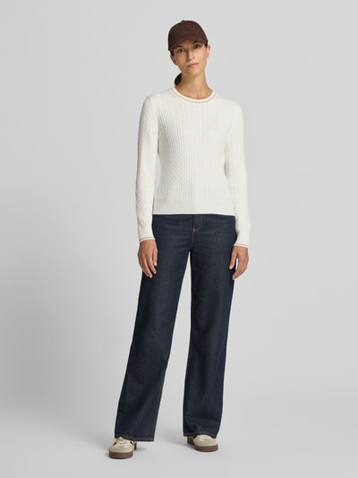 Frauenmodel trägt weißen Slim Fit Pullover aus Baumwoll-Mix von Lacoste, strukturierte Oberfläche, kombiniert mit dunkler Jeans, Ganzkörperansicht von vorne, Damen Pullover von Lacoste.