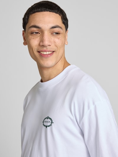 Mężczyznamodel nosi męski t-shirt Pegador Oversized T-Shirt mit rückseitigem Motiv-Print Modell 'Reine' z bawełny, krój oversized fit, okrągły dekolt, nadruk z logo, biała gładka faktura, zbliżenie na górną część ciała, widok z przodu
