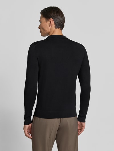 Männermodel trägt schwarzen Strickpullover mit Viskose-Anteil Modell 'MANICA LUNGA' von MARKUP, glatte Textur, Ganzkörperansicht Rückansicht.