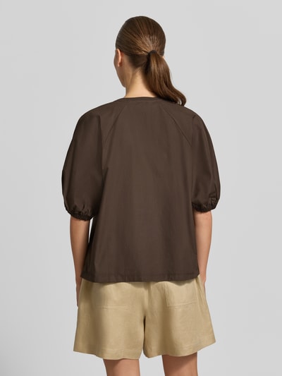 Männermodel trägt T-Shirt mit Rundhalsausschnitt Modell 'CELLULA' von MM by Max Mara, czysta bawełna, krój relaxed fit, długość pleców w rozmiarze S: 59 cm, ciemny brąz, lekkie marszczenia na rękawach, luźny fason, widok całej sylwetki z tyłu.