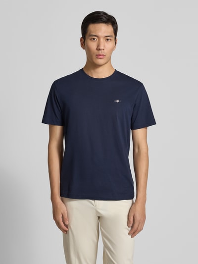 Männermodel trägt Regular Fit T-Shirt mit Label-Stitching Modell 'SHIELD' von GANT, Unifarbenes-Design, Reine Baumwolle, Rundhalsausschnitt, Ganzkörperansicht von vorne.