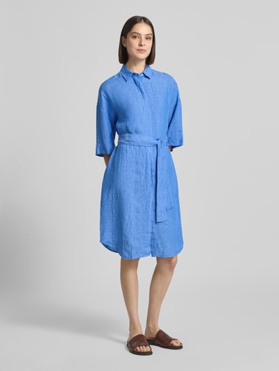 Vrouwenmodel draagt Leinenkleid aus reinen Leinen Modell 'Derby' van 0039 Italy in blauw, getailleerd, halflange mouwen, platte kraag, doorlopende knoopsluiting, semi-transparant design, afneembare stoffen band, ruglengte maat S 96 cm, borstwijdte S 59 cm, mouwlengte S 24 cm. Ganzlichaanszicht van voren.