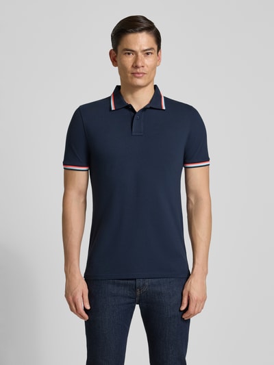 Męski model nosi koszulkę polo Slim Fit Poloshirt mit Kontraststreifen Modell 'Brice' von Sundek, mieszanka bawełny i elastanu, krój slim fit, paski w kontrastowym kolorze, listwa guzikowa, długość tyłu w rozmiarze M: 70 cm, Ganzkörperansicht von vorne.