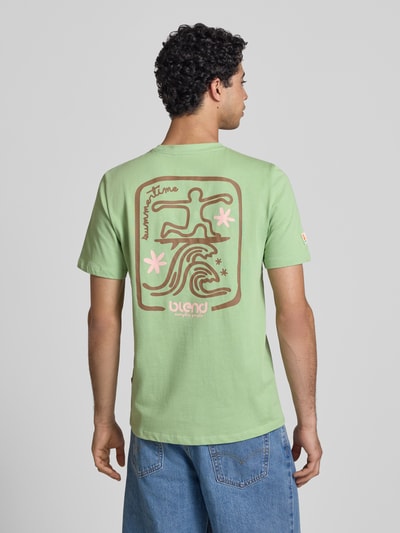 Männermodel trägt T-Shirt mit Motiv-Print Modell 'SUN SURF' von Blend, hellgrün, braun-rosa Print, Baumwolle, Regular Fit, Ganzkörperansicht Rückansicht