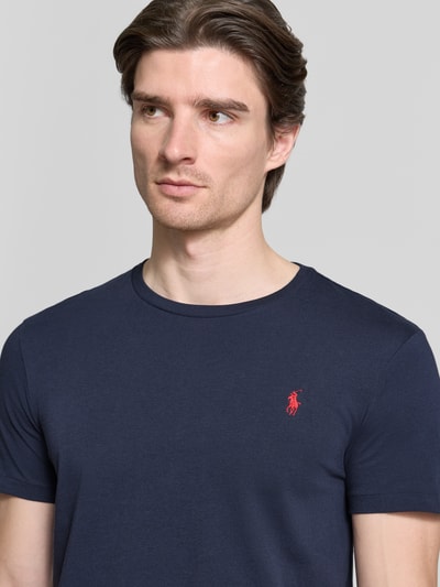 Männermodel trägt dunkelblaues 'Slim Fit T-Shirt mit Logo-Stitching' von Polo Ralph Lauren aus Baumwolle, Nahaufnahme Oberkörper