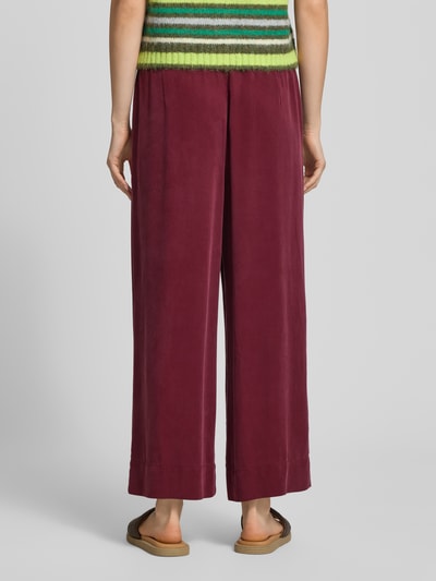 Frauenmodel trägt Weite Hose aus Lyocell von Marc O'Polo Denim in Optik: Unifarben, Regular-Fit, elastischer Bund, Ganzkörperansicht Rückansicht.