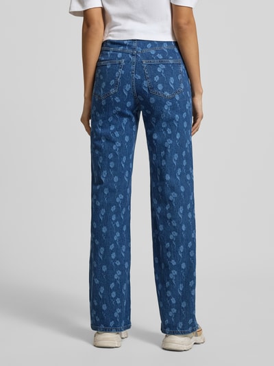 Frauenmodel trägt Wide Leg Jeans aus Baumwoll-Mix Modell 'TESSA' von Vero Moda, blau mit floralem Allover-Muster, 5-Pocket-Design, Ganzkörperansicht Rückansicht.