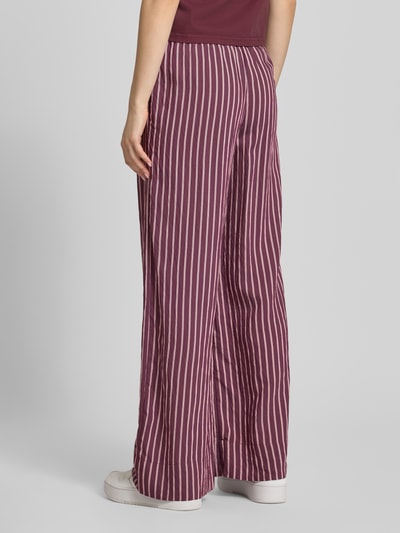 Frauenmodel trägt Regular Fit Weite Hose aus Viskose-Mix Modell 'MELDOLA' von Only, mehrfarbig gestreift, Ganzkörperansicht Rückansicht.