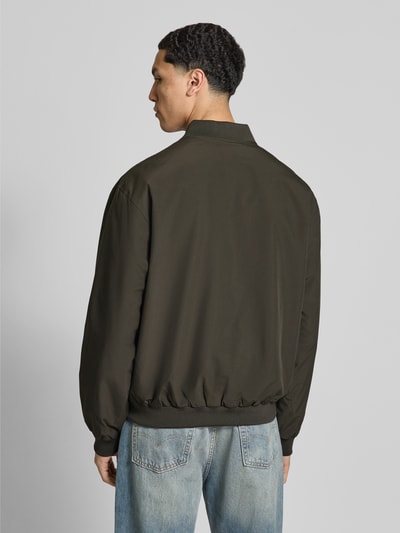 Männermodel trägt Bomberjacke mit Stehkragen Modell 'CHARGE' von Jack & Jones, Regular-Fit, oliv, strukturierte Oberfläche, Ganzkörperansicht Rückansicht, Rückenlänge 67 cm, Schulterbreite 53 cm, Brustweite 62 cm, Ärmellänge 65 cm.