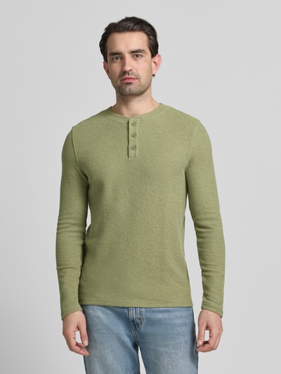 Männermodel trägt Regular Fit Longsleeve mit Knopfleiste von MCNEAL in grün aus elastischem Baumwoll-Mix mit Strukturmuster, Ganzkörperansicht von vorne.