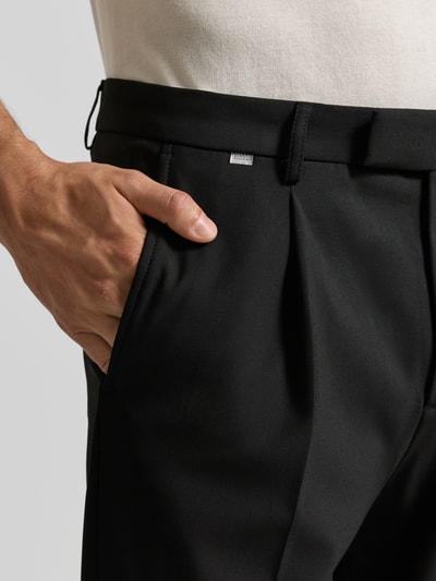 Männermodel trägt schwarze Straight Fit Hose mit Viskose-Anteil Modell 'Salto' von CINQUE, Nahaufnahme Oberkörper, Kontext: elastischer Material-Mix, Bundfalten, Gesäßtaschen, Haken- und Reißverschluss