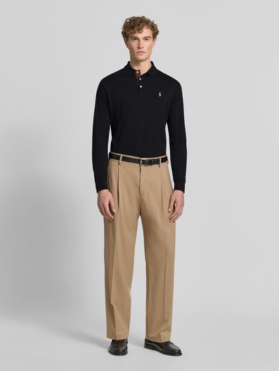 Mannenmodel draagt zwart slim fit poloshirt uit puur katoen van Polo Ralph Lauren, lichtbeige pantalon, geheellichaamsvooraanzicht.
