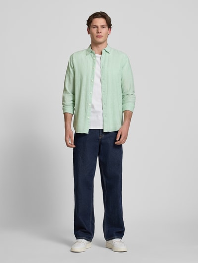 Männermodel trägt Slim Fit Freizeithemd aus Baumwoll-Leinen-Mix Modell 'CAIDENLS SOLID' von Only & Sons, uni mintgrün, ganzkörperansicht von vorne.