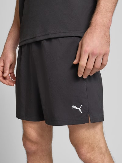 Männermodel trägt schwarze Shorts mit Logo und elastischem Bund von PUMA PERFORMANCE, Regular Fit, Nahaufnahme Oberkörper.