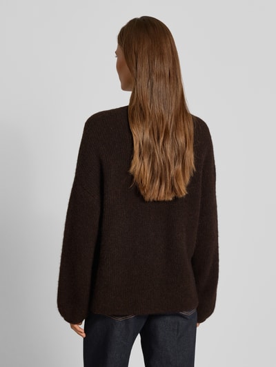 Frauenmodel trägt Relaxed Fit Pullover aus Woll-Alpaka-Mix Modell 'Alpha' von Gestuz, dunkelbraune Strick-Optik, Rückenansicht, KI-modifiziertes Bild.