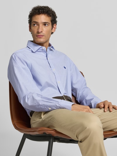 Männermodel trägt Slim Fit Businesshemd aus reiner Baumwolle von Polo Ralph Lauren in Hellblau, dezente Struktur, Nahaufnahme Oberkörper.