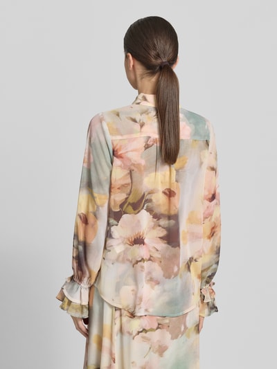 Frauenmodel trägt Regular Fit Bluse mit Rüschen Modell 'CARMEN' von Soyaconcept im Allover-Look mit Hemdblusenkragen, Rückenlänge 58 cm, Ärmellänge 64 cm, helle florale Farben, fließende Textur, Ganzkörperansicht Rückansicht.
