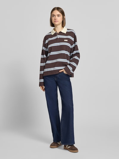 Vrouwenmodel draagt Wide Leg Jeans aus Baumwoll-Mix Modell 'JUDY' van Only, effen denim, low waist, 5-pocket, labelstiksel, donkerblauw, geheellichaamsaanzicht van voren.