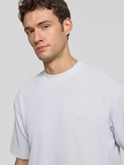 Männermodel draagt Regular Fit T-shirt uit katoenmix Model 'TE_HIVE' van BOSS Orange, effen look, structuurpatroon, ronde hals, korte mouw, jacquard, labeldetail, Nahaufnahme bovenlichaam.
