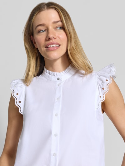 Frauenmodel trägt weiße Regular Fit Bluse aus reiner Baumwolle Modell 'BALVANA' von BOSS Orange mit Lochspitze und Volants, Nahaufnahme Oberkörper.