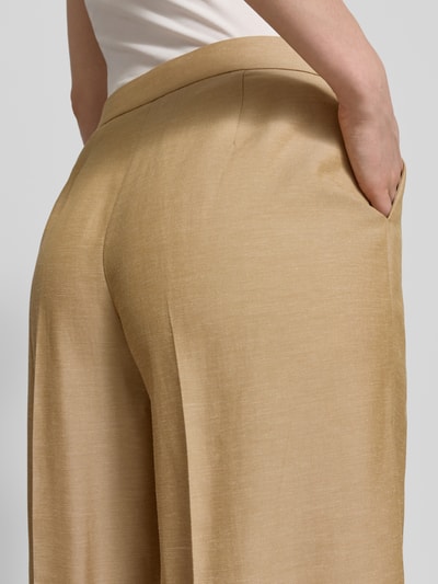 Frauenmodel trägt Wide Fit Stoffhose mit Lyocell-Anteil von Comma, Material-Mix, Eingrifftaschen, sandfarben, Detailaufnahme Rückansicht.