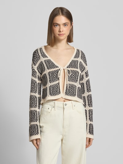 Modelka nosi Regular Fit Strickjacke aus Baumwoll-Mix Modell 'LOA' od Only, dwukolorowa, wzór krata, dzianina, krój regular fit, z wiązaniem, długi rękaw, mieszanka bawełny; widok na górną część ciała z przodu.