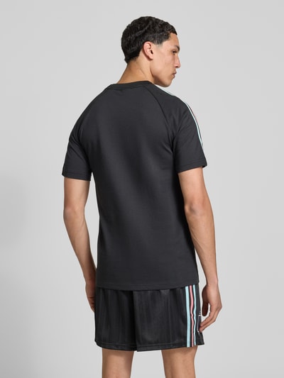 Männermodel trägt Regular Fit T-Shirt aus Baumwoll-Mix Modell 'RBFA OG' von adidas Originals in Schwarz mit Optik: Unifarben, Rückansicht, Ganzkörperansicht