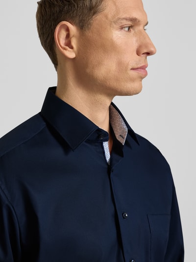 Männermodel trägt Comfort Fit Business Hemd aus Baumwolle mit Kentkragen von ETERNA, dunkelblau, Brusttasche, Nahaufnahme Oberkörper.