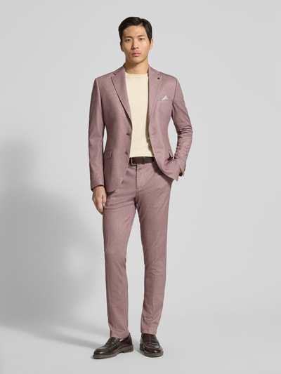 Męski model nosi Slim Fit 2-Knopf-Sakko mit Pattentaschen von Zuitable, mieszanka materiałów z dodatkiem lyocellu, krój slim fit, kołnierz z połami, zapięcie na 2 guziki, kieszenie z patką, szerokość w rozmiarze 50: 43 cm, długość wewnętrzna nogawki w rozmiarze 50: 81 cm, całkowity widok z przodu.