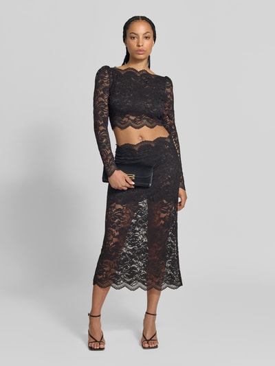 Kobiece model nosi bluzkę z długim rękawem 'Cropped Langarmbluse aus Spitze' od Rabanne, elastyczna mieszanka materiałów, krój krótki, krój slim fit, koronka, półprzezroczysty materiał, Długość tyłu w rozmiarze 38: 40 cm, Długość rękawów w rozmiarze 38: 68 cm, czarny kolor, wzór koronkowy, cała sylwetka z przodu.