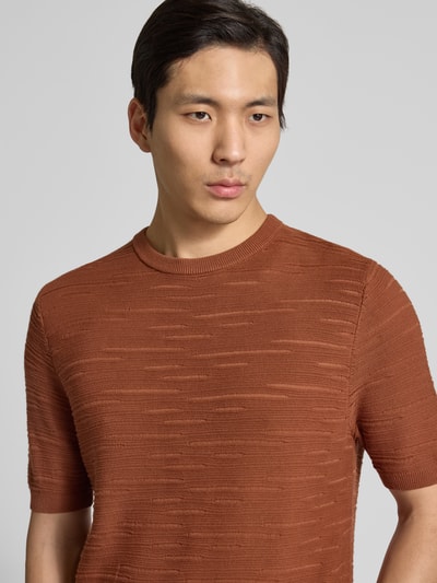 Männermodel trägt Strickshirt aus Baumwolle von Antony Morato in Rostbraun, Gerader-Schnitt, Rundhalsausschnitt, Halbarm, Nahaufnahme Oberkörper.