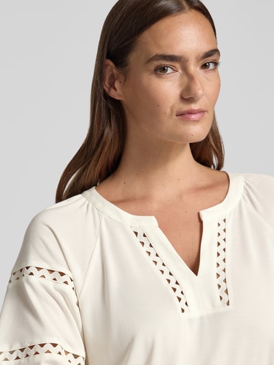 Vrouwenmodel draagt Relaxed Fit T-shirt uit modal-mix van s.Oliver BLACK LABEL in crème met opengewerkte details, close-up bovenlichaam.