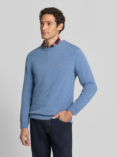 Męski model nosi jasnoniebieski sweter regular fit z czystej wełny marki GANT, gładka faktura, sweter wełniany, Ganzkörperansicht von vorne