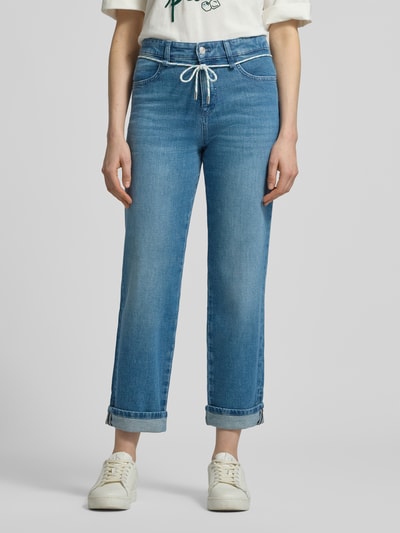 Kobiece modelka nosi Straight Fit Jeans mit fixierten Beinabschlüssen od Marc Cain, niebieski elastyczny bawełniany materiał, kieszenie z przodu i z tyłu, zapięcie na guzik i zamek, szerokość w rozmiarze 36: 39 cm, długość wewnętrzna nogawki: 71 cm, całkowity widok z przodu