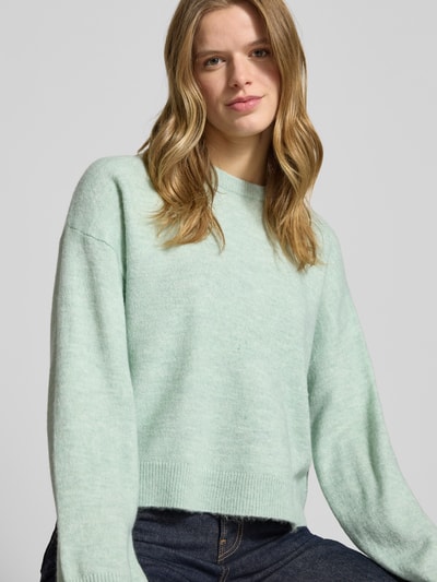 Frauenmodel trägt Relaxed Fit Strickpullover mit Crew Neck Modell 'SIMONI' von Only in Melange-Optik, Rundhals, langarm, Nahaufnahme Oberkörper.