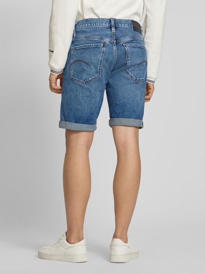 Männermodel trägt Jeansshorts mit Umschlag Modell 'Mosa' von G-Star Raw im Used-Look, Regular Fit, Ganzkörperansicht Rückansicht