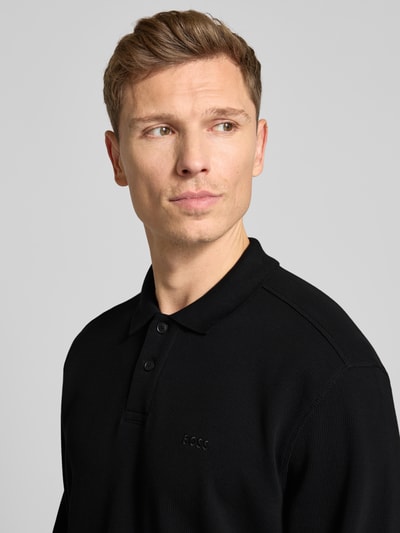Męski model nosi Regular Fit Koszulka polo z mieszanki bawełny Model 'PETEMPESTOLONG' od BOSS Orange, efekt: jednolity kolor, wyhaftowane logo, kołnierzyk koszulowy, zapięcie na 2 guziki, długi rękaw, wykończenie: pika, prążki, ujęcie: zbliżenie górnej części ciała.