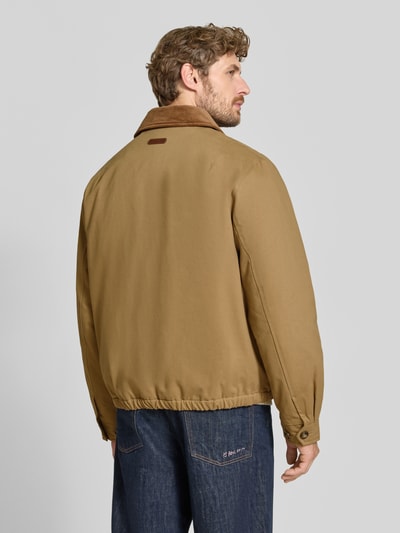 Männermodel trägt eine beigefarbene Regular Fit Bomberjacke aus reiner Baumwolle Modell 'HARRINGTON' von GANT, Herren Bomberjacke, Ganzkörperansicht Rückansicht.