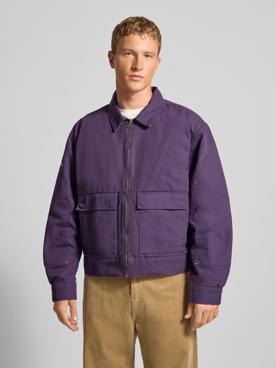 Männermodel trägt Jacke aus Wolle mit Pattentaschen Modell 'DOGMA WORK JACKET' von Edwin in Lila, Regular-Fit, Reißverschluss, Ganzkörperansicht von vorne, Kontext: Herren Jacke, Reine Wolle, Rückenlänge 65 cm, Schulterbreite 46 cm, Brustweite 43 cm, Ärmellänge 65 cm.