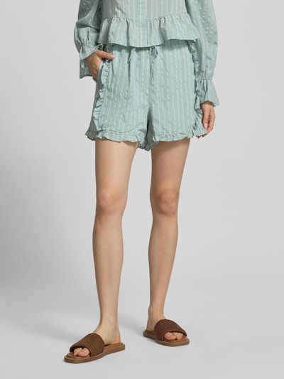 Frauenmodel trägt Shorts aus Viskose-Mix mit Volants Modell 'Vale' von OH APRIL, in hellem Blau, Regular-Fit, Ganzkörperansicht von vorne, Bundweite 36 cm, Innenbeinlänge 37 cm, leichte Struktur und feine Streifen.