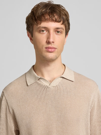 Männermodel trägt Regular Fit Strick-Poloshirt Modell 'CASSIS' von Jack & Jones, beige, Baumwolle, V-Ausschnitt, Nahaufnahme Oberkörper.