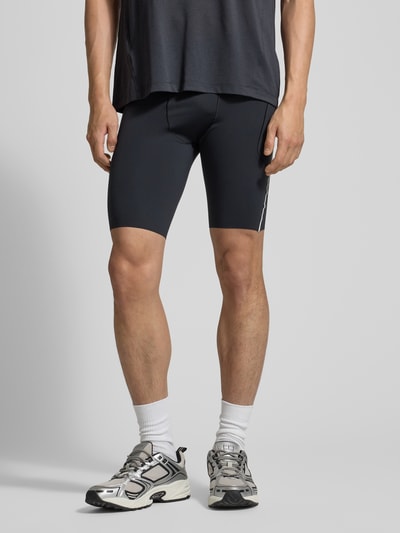 Männermodel trägt Tights mit Logo und Reißverschlusstasche von Salomon, Material-Mix mit Stretch, körpernahe Passform, Ganzkörperansicht von vorne.