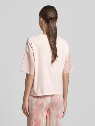 Frauenmodel trägt T-Shirt mit Rundhalsausschnitt und Tunnelzug von Marc Cain aus Baumwoll-Elasthan-Mix im Relaxed-Fit, Ganzkörperansicht Rückansicht.
