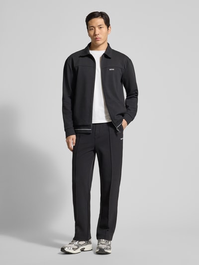 Männermodel trägt Regular Fit Sweatpants aus Baumwoll-Mix Modell 'JT_Member Hurley' von BOSS Green, unifarben, Label Stitching, fixierte Bügelfalten, Tunnelzug, elastischer Bund, seitliche Eingrifftaschen, angedeutete achterzak, sweatmateriaal. Ganzkörperansicht von vorne.