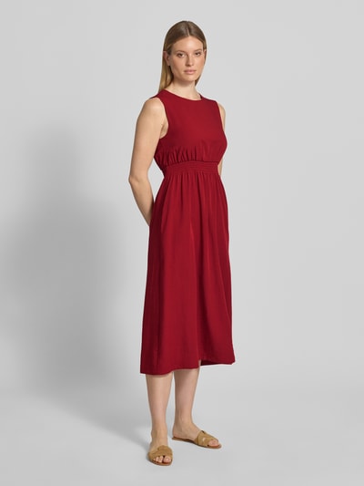 Frauenmodel trägt Midikleid aus Viskose-Mix mit Leinen-Anteil A-Linie Rundhalsausschnitt Taillenband Modell 'Daria' von MSCH Copenhagen, Ganzkörperansicht von vorne.