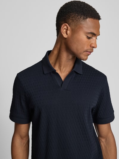 Męski model nosi Regular Fit koszulkę polo z dekoltem w serek model 'Rauljose' od JOOP! Collection, bawełna, fakturowany wzór, długość tyłu w rozmiarze M 69 cm, zbliżenie górnej części ciała z przodu.