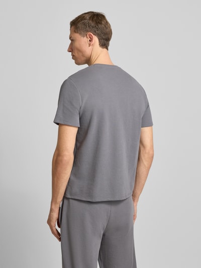 Männermodel trägt Regular Fit T-Shirt aus Baumwoll-Mix von BOSS, Optik: Unifarben, Waffel-Struktur, Kurzarm, Rückansicht Ganzkörperansicht.