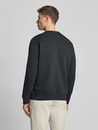 Mannenmodel draagt sweatshirt met logo en ronde hals van GAP, katoenmix, regular fit, zwarte stof, ruglengte maat M 69 cm, mouwlengte 65 cm, geheelbeeld achteraan