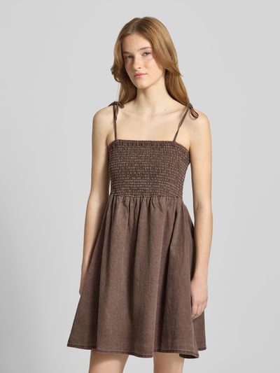 Frauenmodel trägt Minikleid mit Smok-Detail Modell 'Oregon' von Noisy May aus Reine Baumwolle, braun, taillierte Passform, Spaghetti-Träger, Nahaufnahme Oberkörper.